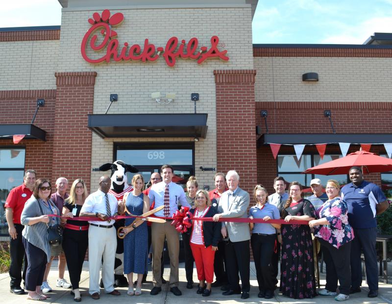 Ribbon-cutting attendees shown are (l-r) Chick-fil-A Marketing Director Charles Gray; chamber board member Janice Elliott; Chick-fil-A dining room host Rick Hazzard; chamber board member Alice Rausch; Mayor Archie Campbell; Chick-fil-A cow mascot; Amy Hobert; Todd Hilliker; owner/operator Chris Hobert; Chick-fil-A Director Brooke Thomas, five years’ service; Chick-fil-A Director Denise Steingrebe, five years’ service; Chick-fil-A dining room host Steve Peterman, five years’ service; chamber President Darel LaPrade; Chick-fil-A Team Leader Lauren Steingrebe; Chick-fil-A Director Andy Sommers; videographer Angela Stanford; raving fan Marvin Schelhouse; chamber Secretary Jennifer Jurczak; and Todd Wilson. SUBMITTED PHOTO
